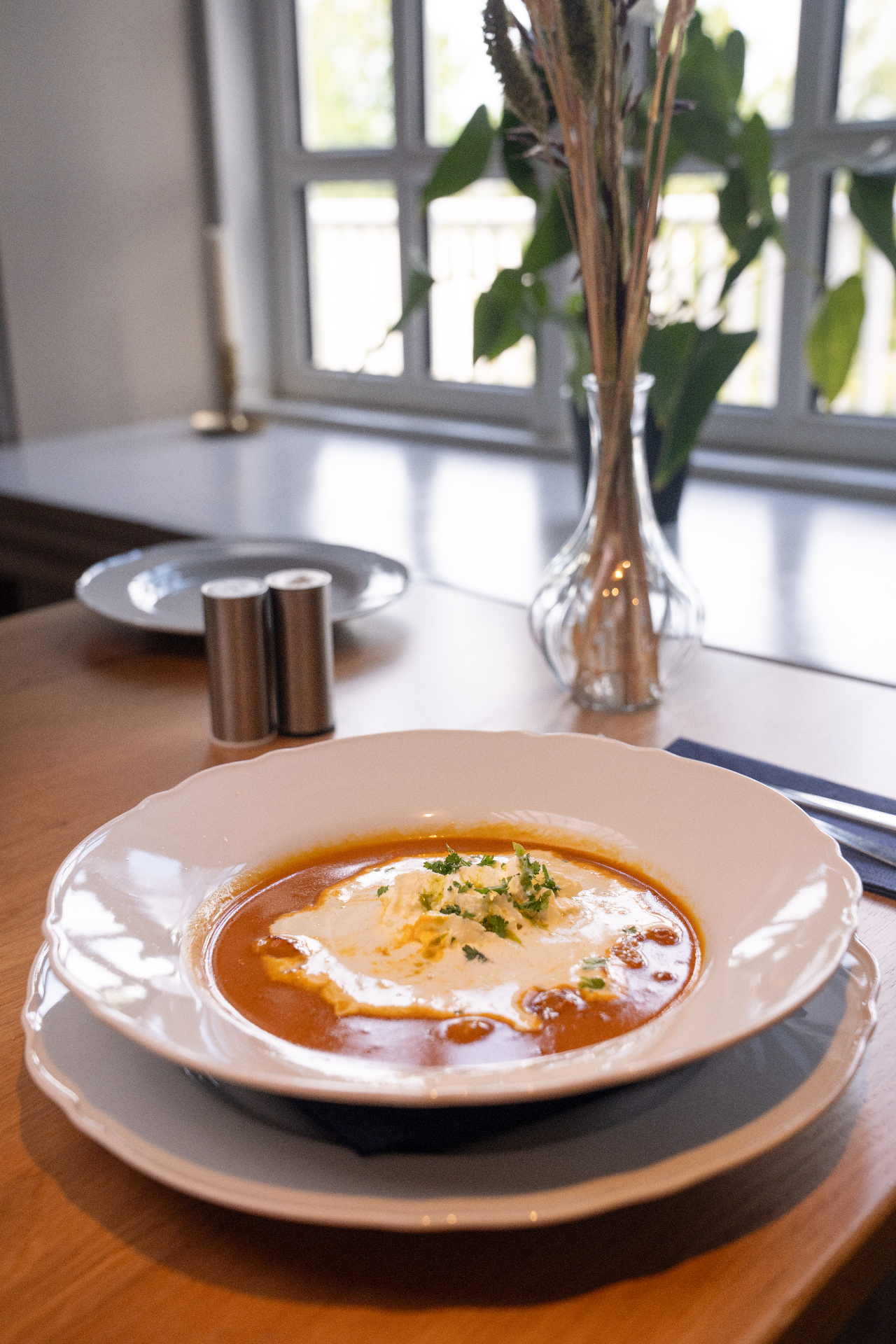 Creamy tomato soup with a swirl of cream and fresh parsley